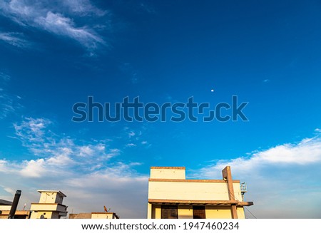 beautiful background with blue sky  clouds and moon,with added noise and grains and selective focus on subject.