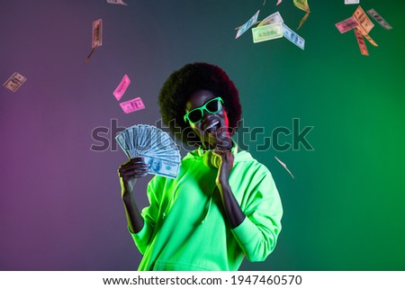 Photo of funny cool dark skin lady dressed sweatshirt eyewear arm earphones holding cash isolated neon background