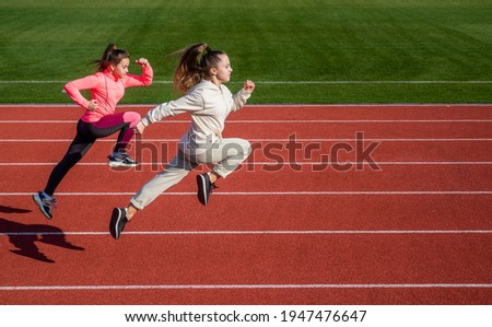 stamina. teenage girls run marathon. runner on race competition. sprinter warming up on stadium gym. children training at school physical education lesson. speed and motion. Just flying Royalty-Free Stock Photo #1947476647