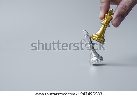 businessman hand moving gold Chess King figure and Checkmate opponent during chessboard competition. Strategy, Success, management, business planning, disruption and leadership concept Royalty-Free Stock Photo #1947495583