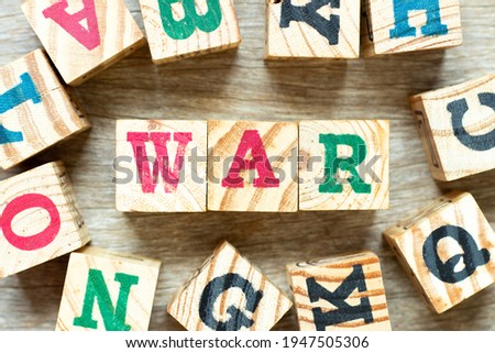 Alphabet letter block in word war with another on wood background