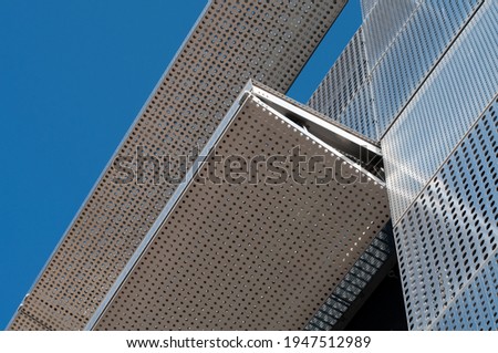 a metal facade of an office building covered with perforated steel sheets on a sunny day Royalty-Free Stock Photo #1947512989