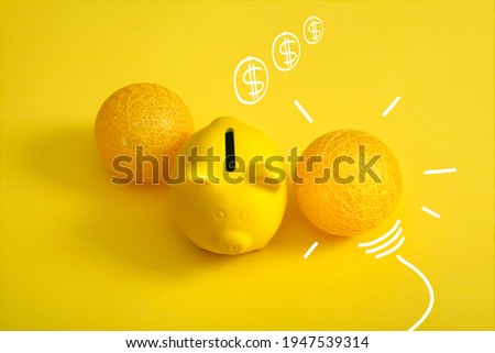 piggy bank with light bulb and drawn coins, saving idea concept. Vivid yellow background.