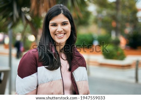 Young hispanic girl smiling happy standing at the park.