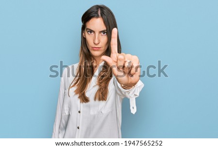 Young beautiful woman wearing casual clothes pointing with finger up and angry expression, showing no gesture 