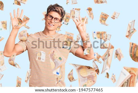 Young handsome man wearing casual clothes and glasses showing and pointing up with fingers number nine while smiling confident and happy.