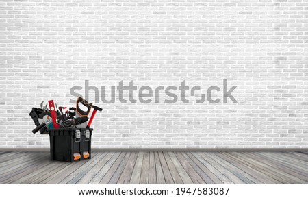 open big tool-box with tool stand in empty home room with brick wall, repair concept Royalty-Free Stock Photo #1947583087