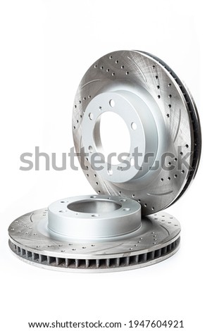 Perforated  brake pads next to brake disc on white background isolated object