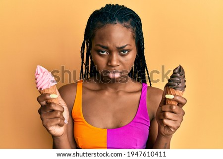 Young african american woman wearing summer style holding ice cream depressed and worry for distress, crying angry and afraid. sad expression. 
