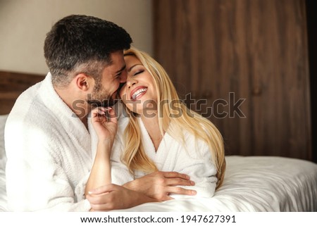 Romantic weekend wedding anniversary. Waking up with gentle touches and kisses in a hotel room. Beautiful couple in a luxury spa hotel fills with positive energy. Moment before kiss, love, couple Royalty-Free Stock Photo #1947627391
