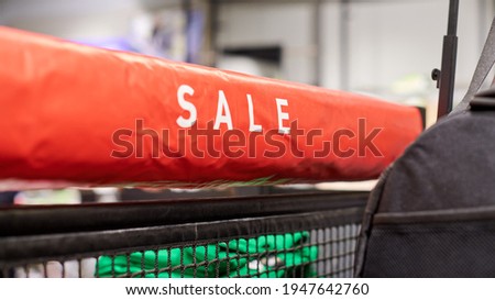 Seasonal sale, holiday discounts in shopping mall, Black Friday. New Year's sale time at european shopping center. Christmas promotions in clothing store. Sportswear and clothes hanging on hangers.