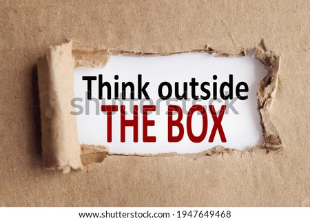 Think outside the box. text on white paper over torn paper background.