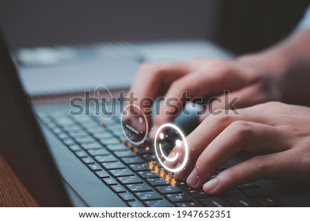 Customer satisfaction survey concept, Businessman using computer laptop select smiley face icon with yellow five stars to evaluate product and service. Royalty-Free Stock Photo #1947652351