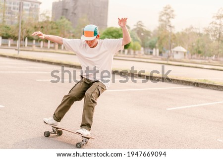 A man playing skateboard in the afternoon at skate park Royalty-Free Stock Photo #1947669094
