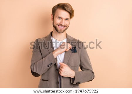Photo of optimistic nice blond hair man hold card wear grey jacket isolated on beige background