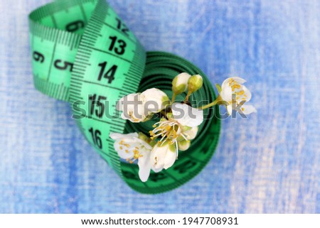 concept with measuring tape and spring flowers