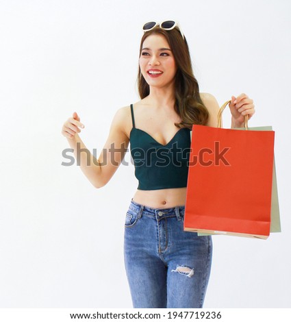 Beautiful asian girl carrying a red shopping bag People who are happy with shopping on the holiday.