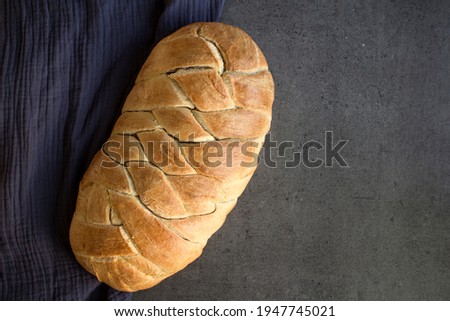 Sweet sourdough bread on blue kitchen towel. Gray background with copy space. Homemade bread top view photo. 