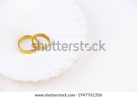 Two golden wedding rings close up on white background. Wedding invitation card concept. 