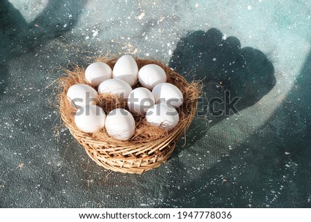 Wooden round basket with eggs for Easter holiday. Background gray. Religious holidays concept, beautiful decor. greeting card