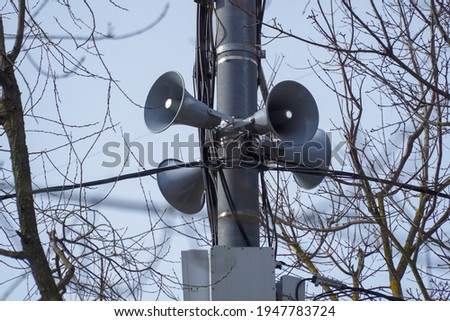  Four loudspeakers are fixed on a pole and directed in different directions for announcements, agitation and broadcasting.                               