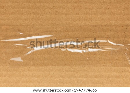 Sticky transparent tape on a cardboard box. Adhesive tape  on the cardboard surface