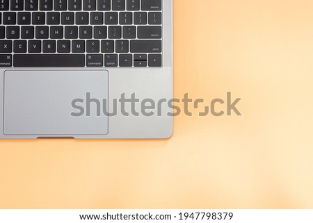 Close up keyboard laptop on orange background