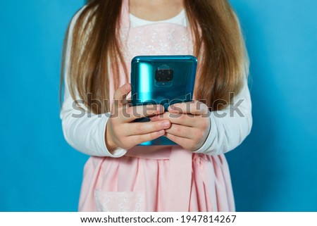 Photo of sweet pretty child girl dressed casual pink outfit holding arms hands modern device isolated blue color background