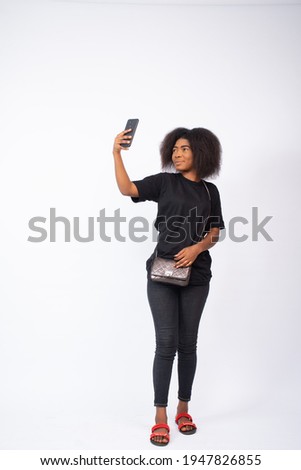 pretty young black woman taking a selfie with her phone