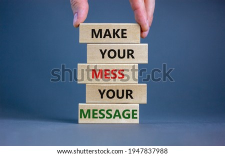 Business concept growth success process. Wood blocks on grey background, copy space. Businessman hand. Words 'make your mess your message'. Conceptual image of motivation.