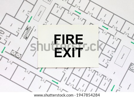 Business card with text Fire Exit on a construction drawing. Concept photo