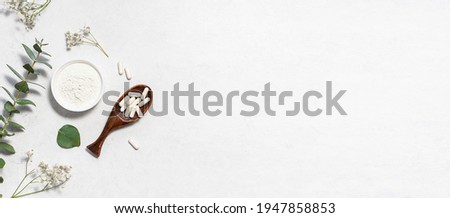 Collagen powder and collagen capsules on white marble background with eucalyptus twigs, long banner format. Skin care concept. Royalty-Free Stock Photo #1947858853