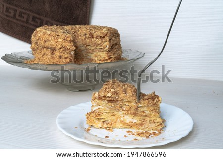 A piece of delicious Napoleon cake and a fork piercing it