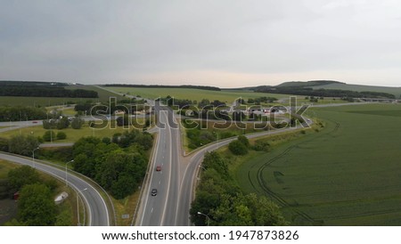 Aerial top down view of highway. Road interchange or highway intersection with busy urban traffic speeding on road. Royalty-Free Stock Photo #1947873826