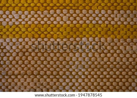Checkered tan and gold squares of a table placemat. Great textured background or wallpaper. The squares alternate colors by row.