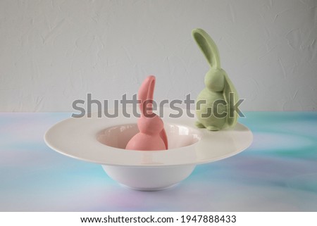 Creative romantic Easter party - a pink bunny talking to a green rabbit. Both bunnies are made of multicolored chocolate by pouring hot chocolate into a mold