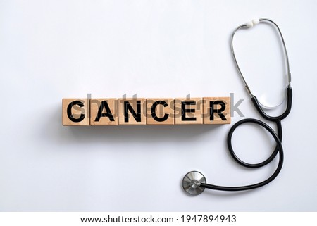cancer word written on wooden blocks and stethoscope on light white background Royalty-Free Stock Photo #1947894943