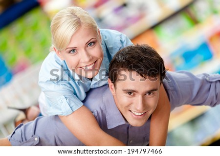 Woman embraces man in the shopping center. Concept of happy relationship and affection