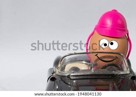 An egg driving a car with a safety helmet