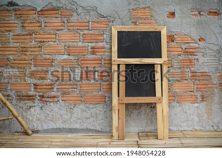 Empty blackboard at wall brick background 