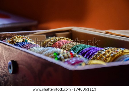 Stock photo of Indian traditional colorful bangles and bracelet kept and decorated in bangle box on blur background, focus on object at Bangalore Karnataka India. Royalty-Free Stock Photo #1948061113
