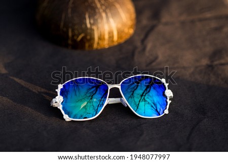 Fashion Sunglasses model with big blue lenses for women with a special design shoot outside in a sunny day . Selective focus 