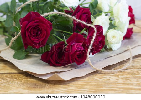 Bright burgundy and colored flowers in a bouquet on brown wooden textured background close-up front view