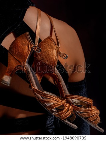 Latino dancer shoes hanging from a girl's shoulder