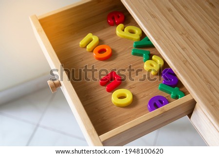 The word No made from colourful letters in wooden drawer shelf in the office table sunlight. Modern Work from home desk due to the covid 19 pandemic. No people. Quarantine, self-isolation, freelance.