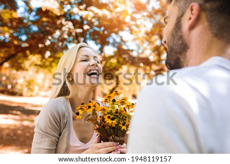 Loving young couple on a date with flowers in the park