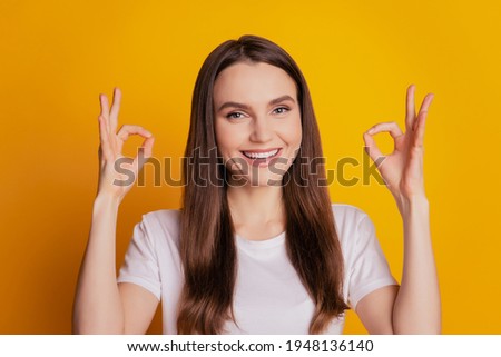 Photo of funny lady show two ok signs wear white t-shirt posing on yellow background