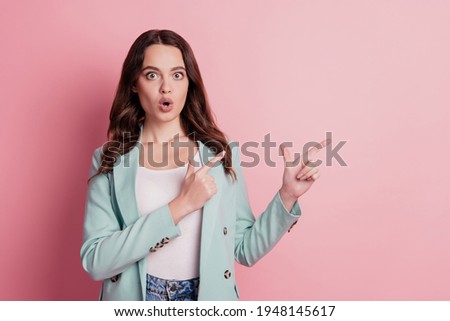 Photo of shocked excited lady direct fingers empty space in fashionable outfit on pink background