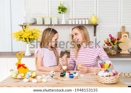 Happy easter . A mother and her daughter painting Easter eggs. Happy family preparing for Easter