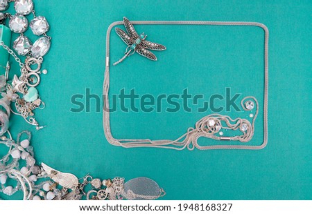 A set of silver jewelry. Space for the text. Blue and silver jewelry on a blue background. Top view.